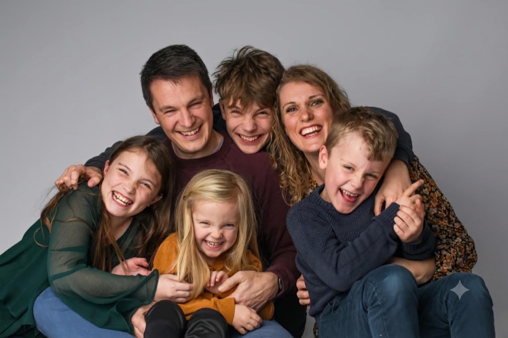 Binni and his wife with their four children, all laughing in a pile